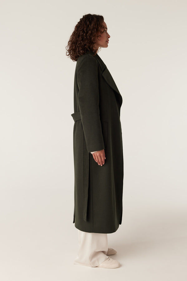 Model wearing a forest green Evans 100% wool tailored wrap coat with fabric belt.