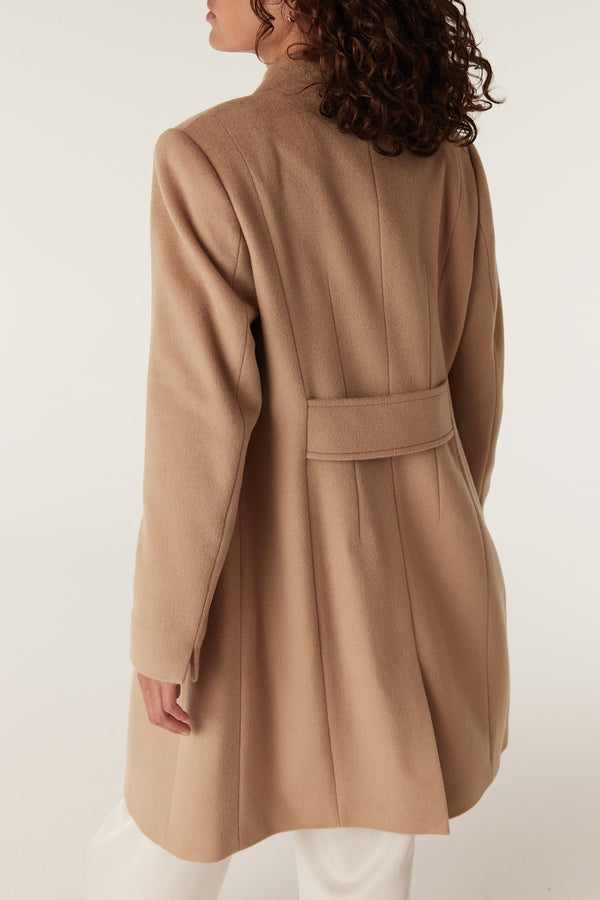 Back view of a woman wearing a camel Eton wool coat with a tailored fit and a decorative back strap.