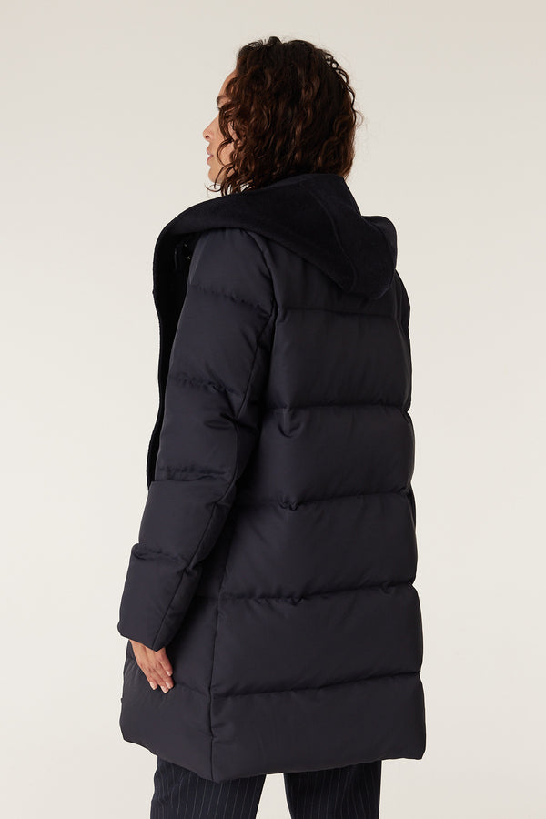 Navy Henderson Puffer jacket with a black fleece-lined hood, shown from the back on a model.