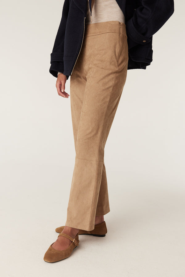 Camel faux suede pants with a straight leg, paired with brown flats and a navy jacket.