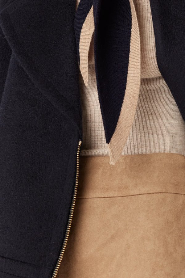 Camel faux suede pants paired with a ribbed top, navy jacket, and striped scarf.