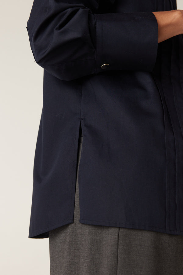 Navy Chester Pintuck Shirt, close-up of side split hem and sleeve cuff with gold button.