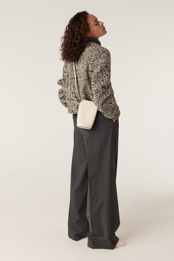 Woman in a Heike Animal print jacket, dark gray wide-leg pants, and a cream crossbody bag.
