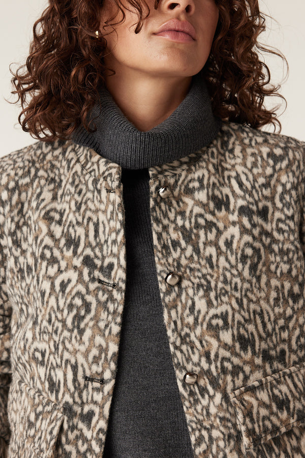 Heike animal print jacket with round neck, button closure, and dark grey turtleneck.