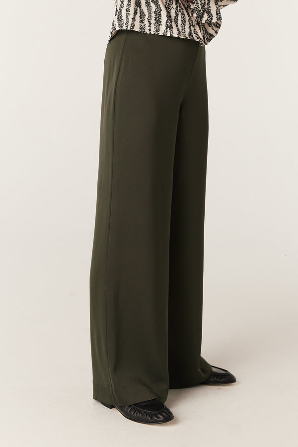 Olive Sibelle wide-leg pants with a smooth, flowing fabric, styled with black flats.