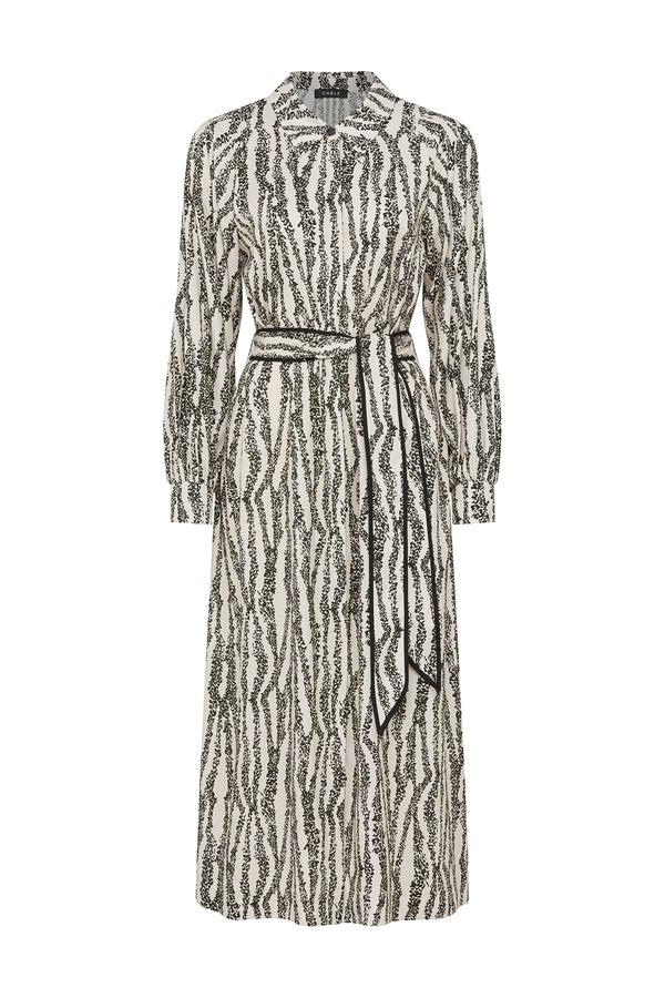 White midi dress with black speckle print, long sleeves, and a tied black waist belt.