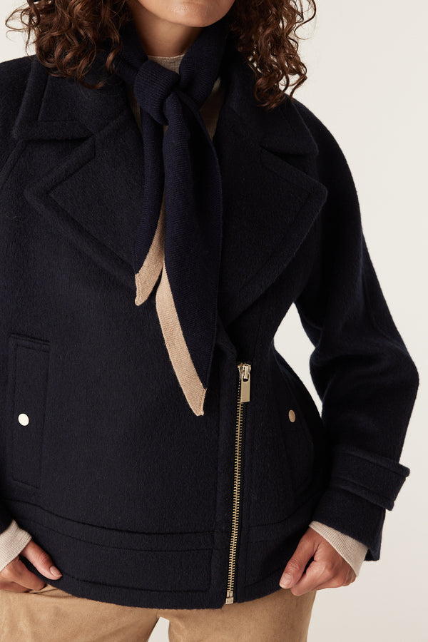 Navy wool Roy jacket with wide lapels, gold zipper, and a matching navy and beige striped scarf.