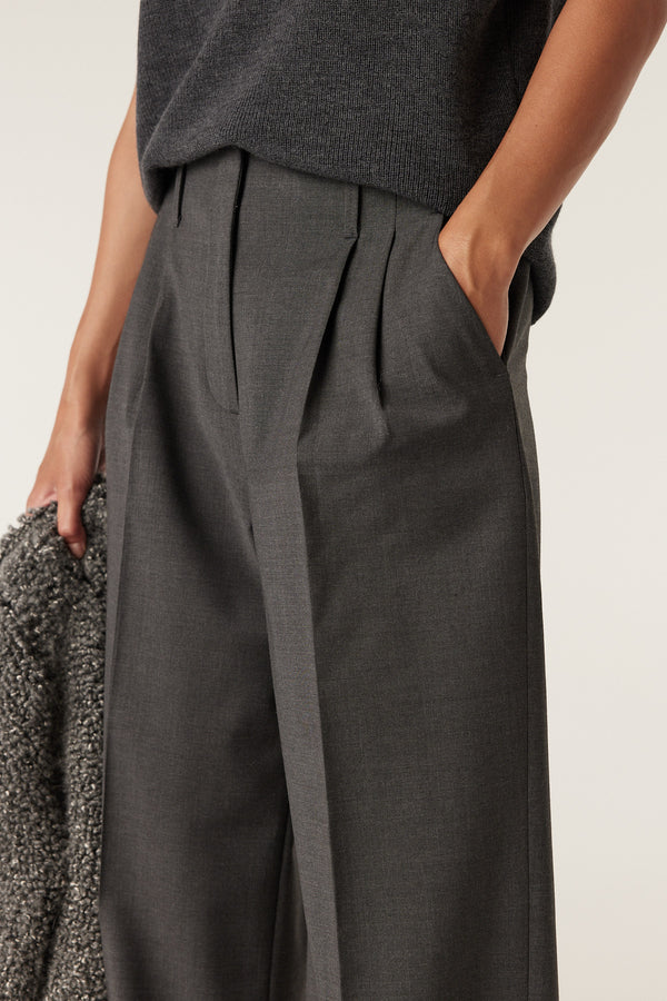 Charcoal marle Lyon wool pant with pleats, a flat front, and a hand in the pocket.