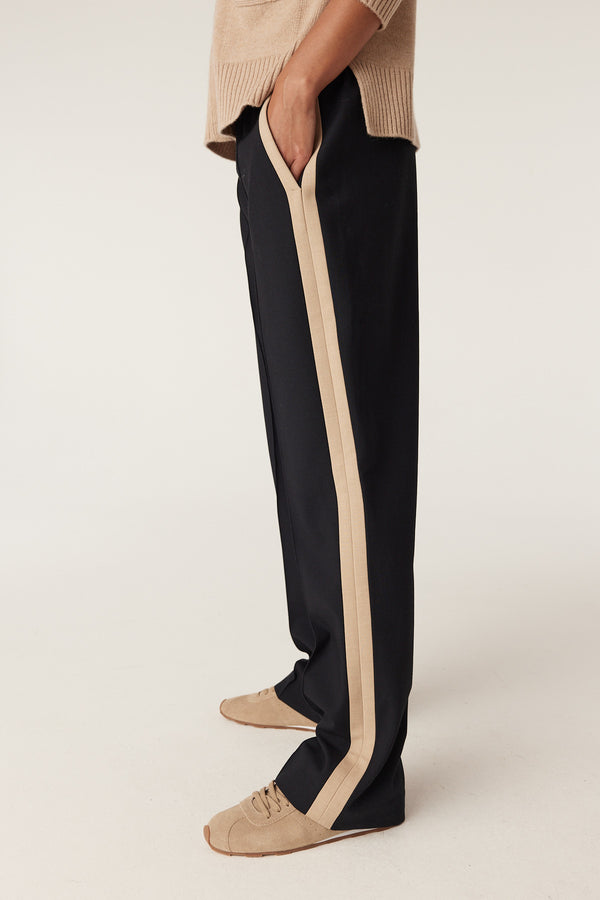 Leah Pant in navy with tan side stripe, worn with tan sweater and sneakers.