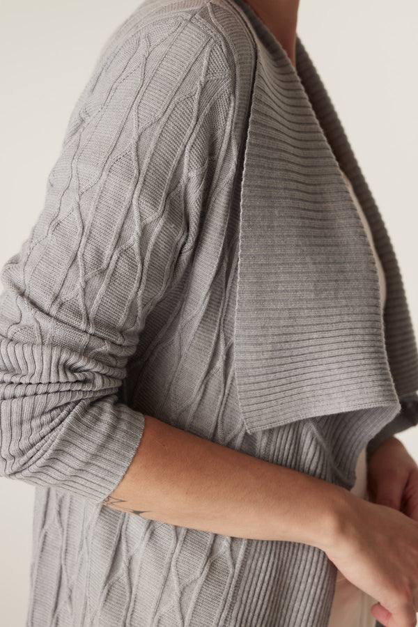 Grey marle Merino wool longline cardigan with cable knit and ribbed collar, shown on a model.
