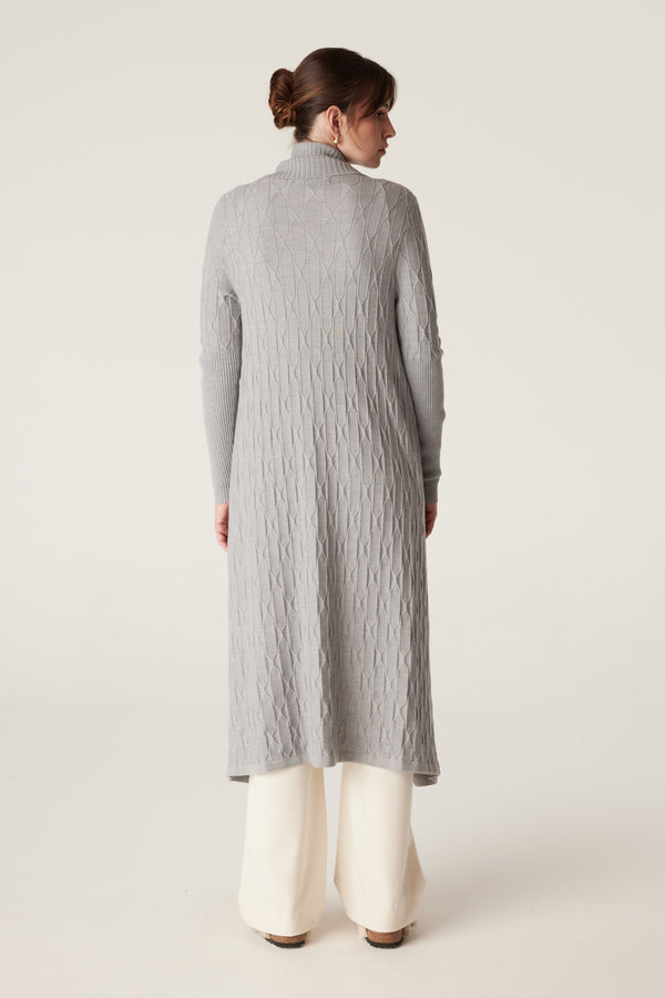 Model wearing a longline grey marle merino wool cable knit cardigan with ribbed sleeves and collar.