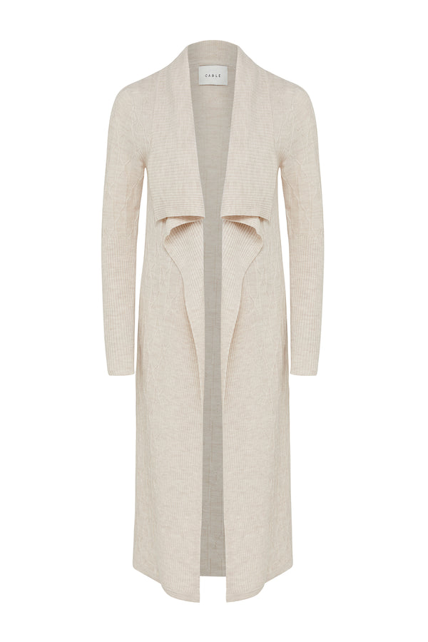 Oatmeal Merino wool longline cardigan with cable knit, ribbed sleeves, and shawl collar.