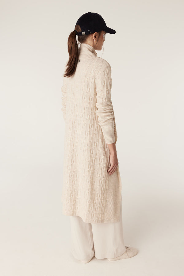 Oatmeal Merino wool longline cardigan with cable knit, ribbed sleeves, and collar, worn by a model.