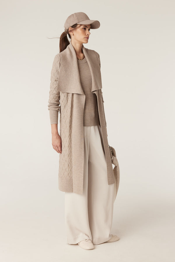 Model wears a pebble Merino wool cardigan with diamond cable stitching, Milano collar, and detachable belt.