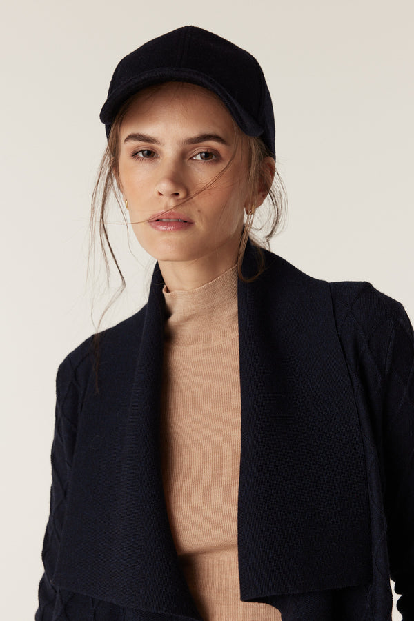 Woman in a Midnight Navy Merino wool cardigan with diamond cable stitching and a Milano collar.