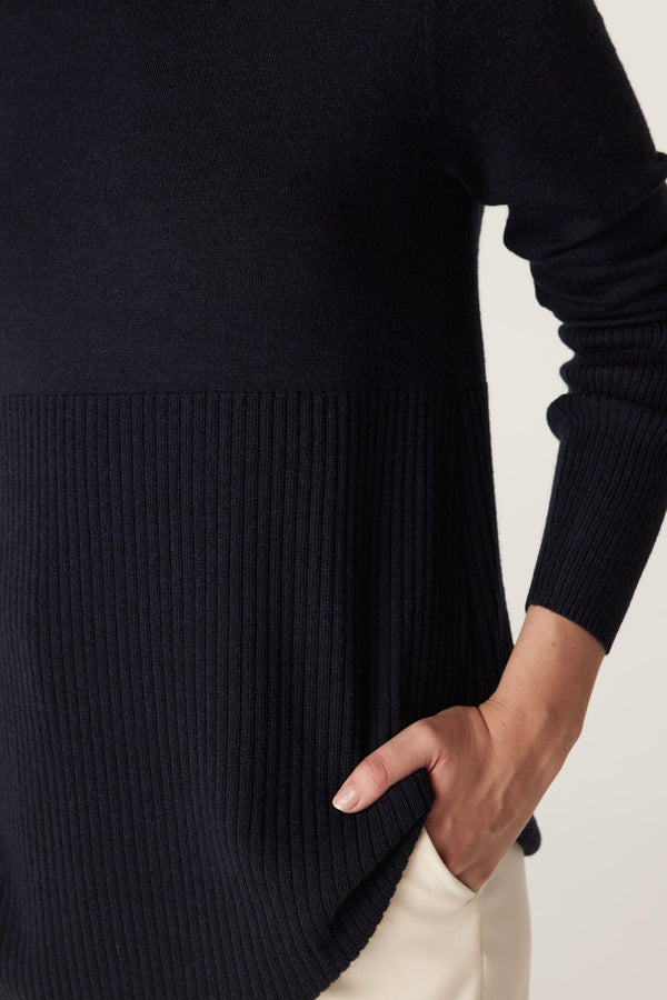 Midnight navy Merino wool jumper with ribbed lower panel and sleeve, A-line shape, and curved hem.