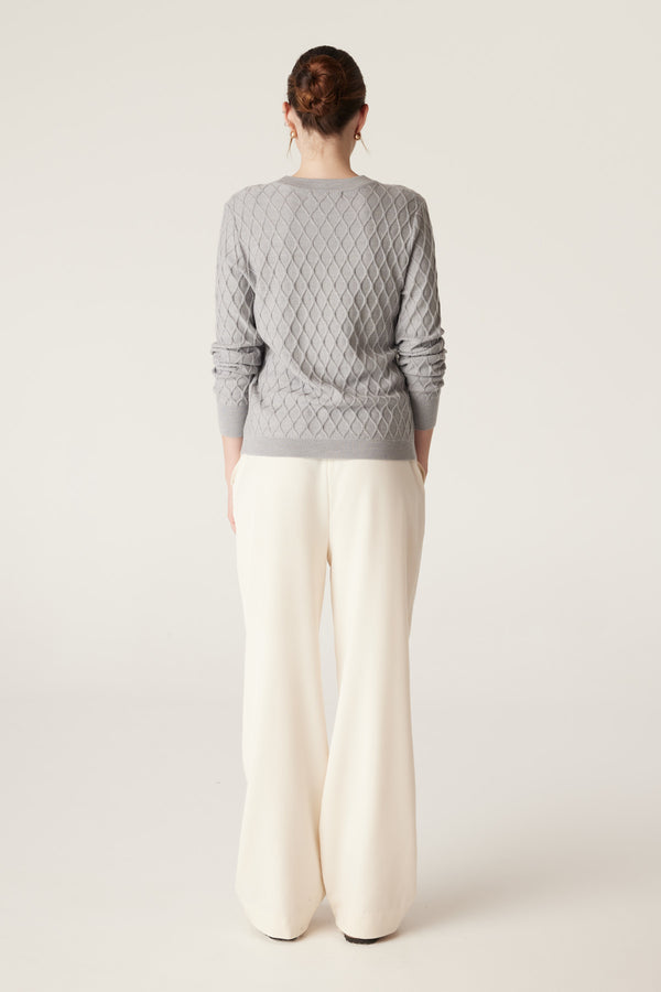 Grey marle Merino wool jumper with diamond cable knit, crew neck, and rib trims, worn by a model.