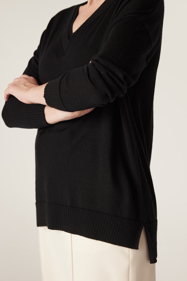 Black merino wool V-neck jumper with dropped shoulders, ribbed cuffs and hem, and side splits.