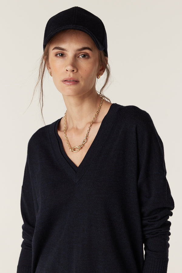 Woman wearing a Midnight Navy Saxon Fine Merino Jumper with a V-neck and dropped shoulders.