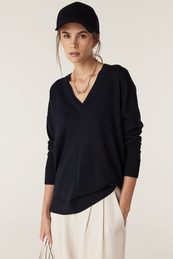 Model wears a Midnight Navy Saxon Fine Merino Jumper with V-neck, dropped shoulder, and rib trims.