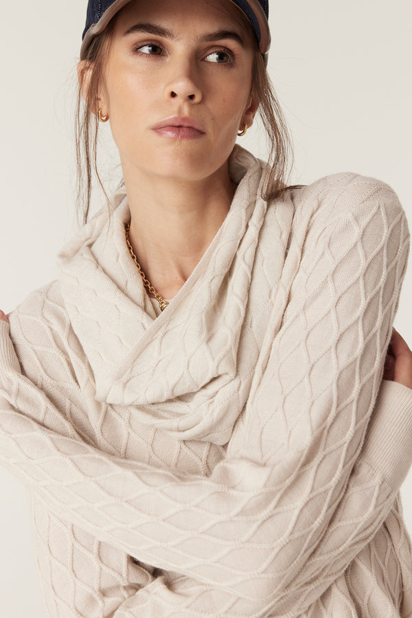 Antique white merino wool snood with diamond cable knit texture worn by a model.