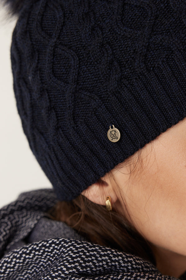 Midnight navy Merino wool beanie with diamond cable knit, ribbed hem, and a small metallic Heritage branded plate.