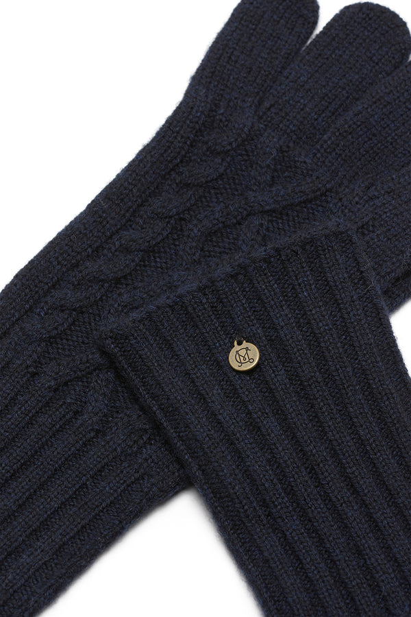 Midnight navy Merino wool gloves with diamond cable knit and ribbed cuffs, featuring a small gold Heritage branded plate.