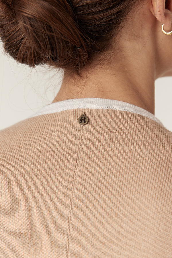 Latte Merino wool cape with white contrast trim and a metallic Heritage branded plate on the back.