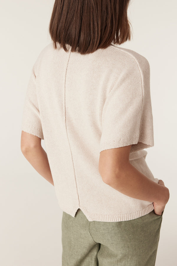 Back view of a calico-colored, medium-weight knit top with short sleeves, a relaxed fit, and a ribbed hem.