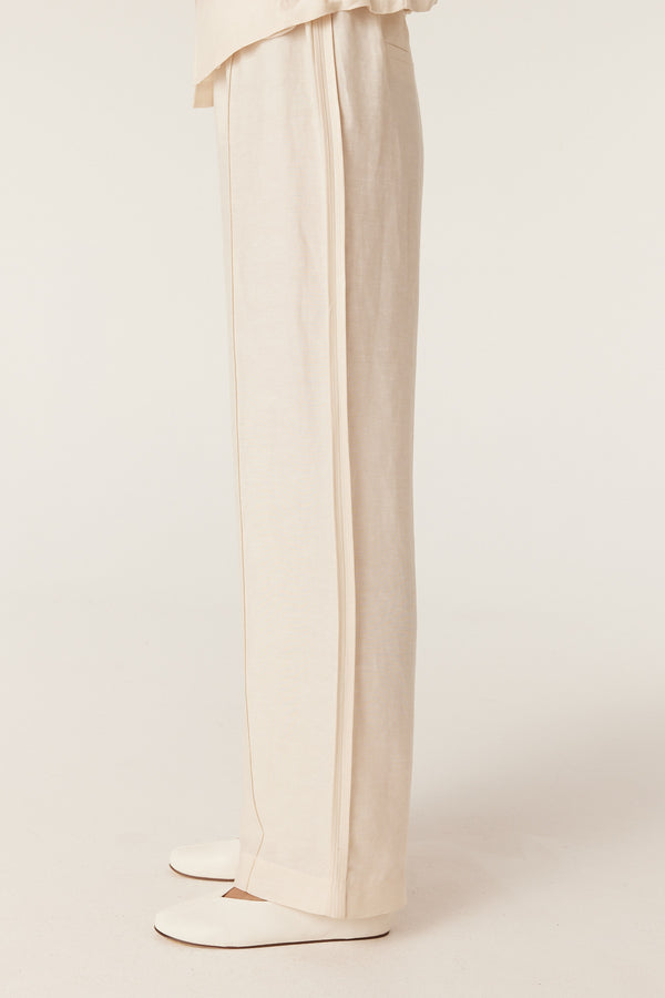 Ecru wide-leg pants with a fluid drape and clean side-seam detailing, shown in a full-length regular fit.