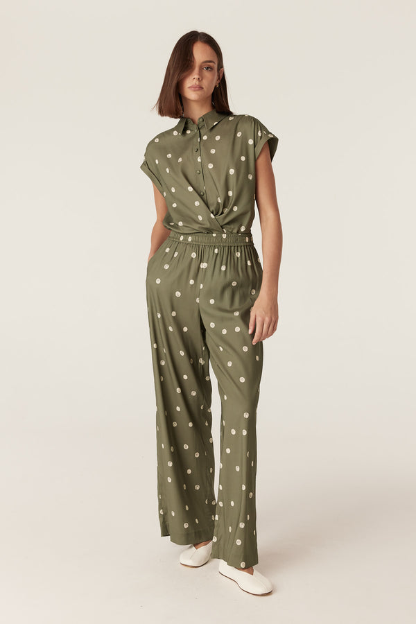 Model wearing green wide-leg pants with white polka dots, featuring an elasticated waist and side pockets.