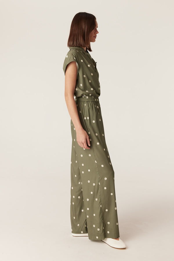 Model wearing green wide-leg pants with white polka dots, featuring an elasticated waist and side pockets.
