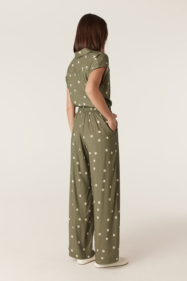 Green wide-leg pants with white polka dots, featuring an elasticated waist and side pockets, worn with a matching blouse.