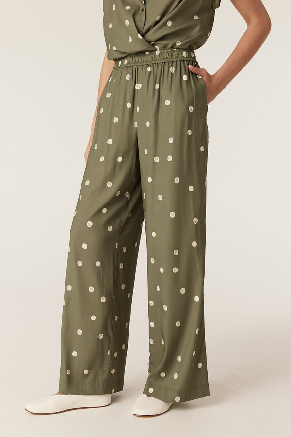 Green wide-leg Muse pants featuring a white polka dot print, elasticated waistband, and convenient side pockets.