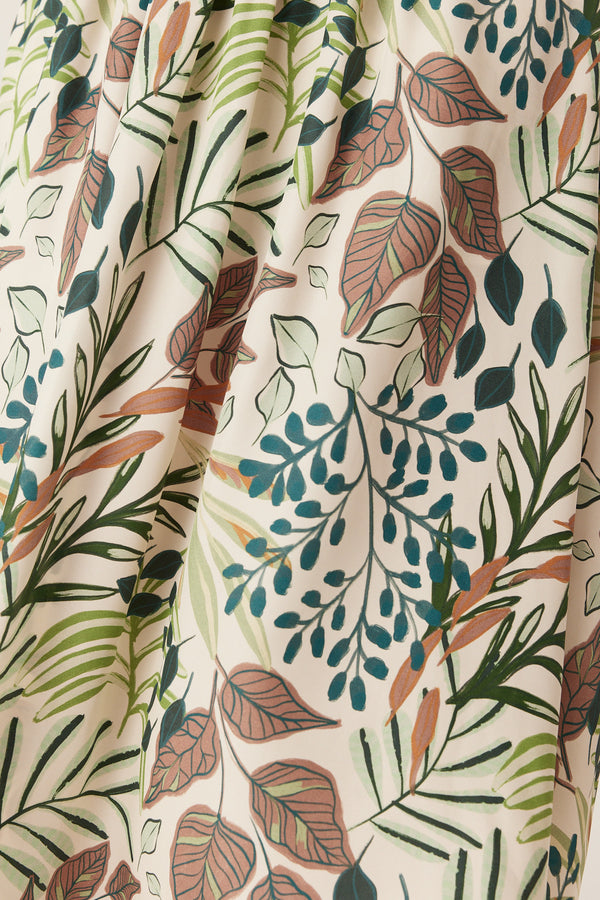 Close-up of the Olivia midi dress featuring an exclusive botanical garden print on lightweight, cream-colored silk fabric.