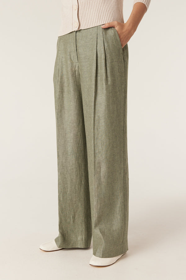 Green wide-leg linen pants with front pleats, belt loops, and side pockets worn with a beige cardigan.