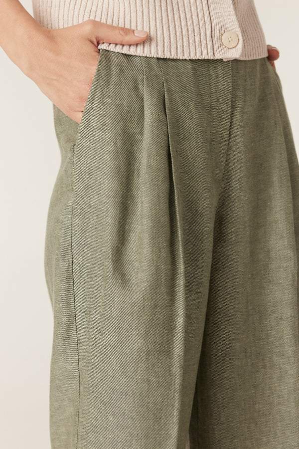 Green wide-leg pants in pure French linen featuring front pleats and side pockets, paired with a beige knit top.