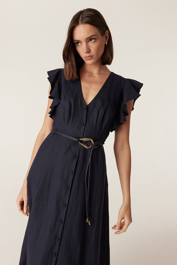 Navy Venetian leather belt featuring a sculptural gold-tone buckle worn over a navy button-down midi dress.